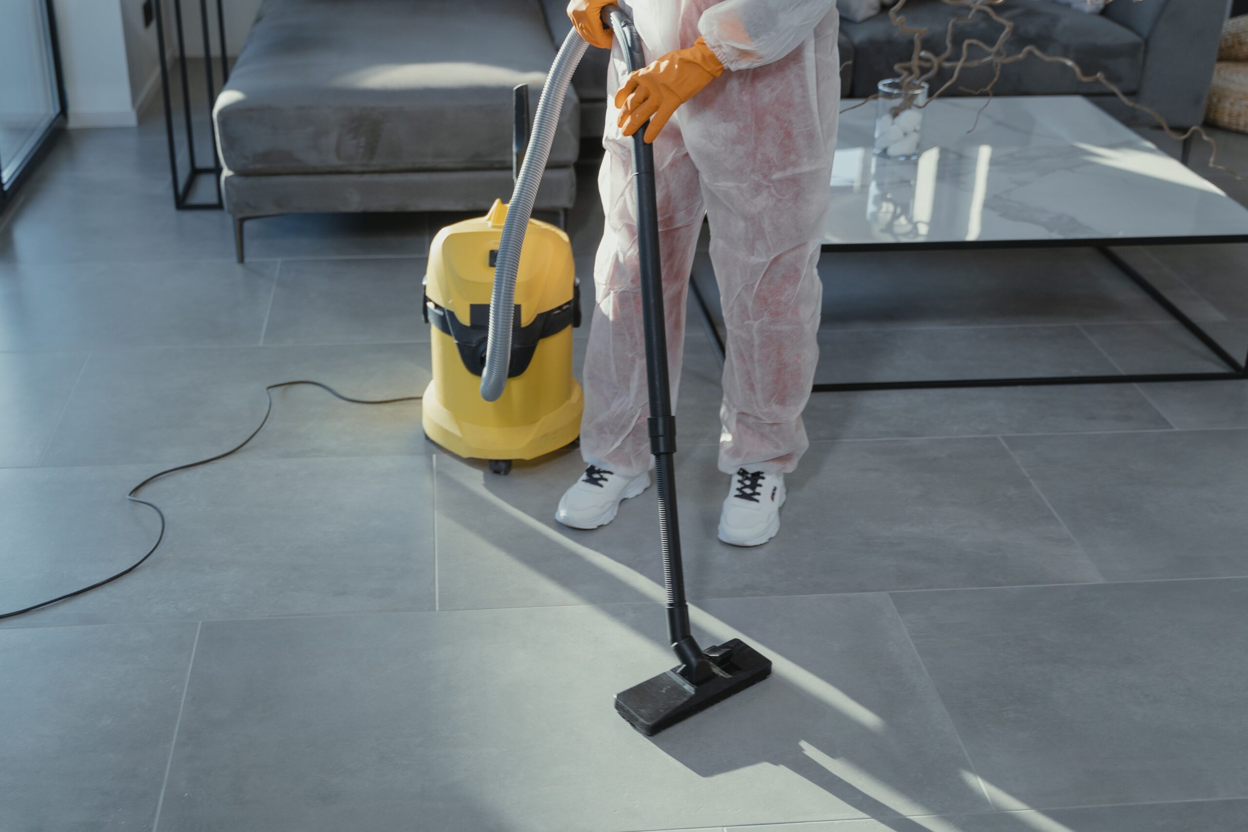 Vacuuming pet hair off a couch in a small apartment